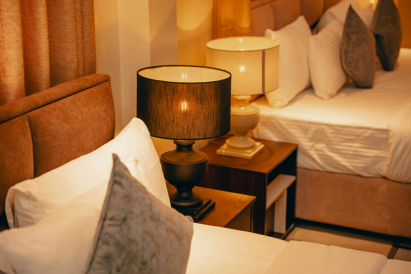 Nachttisch mit warmer Lampe zwischen den Betten.
