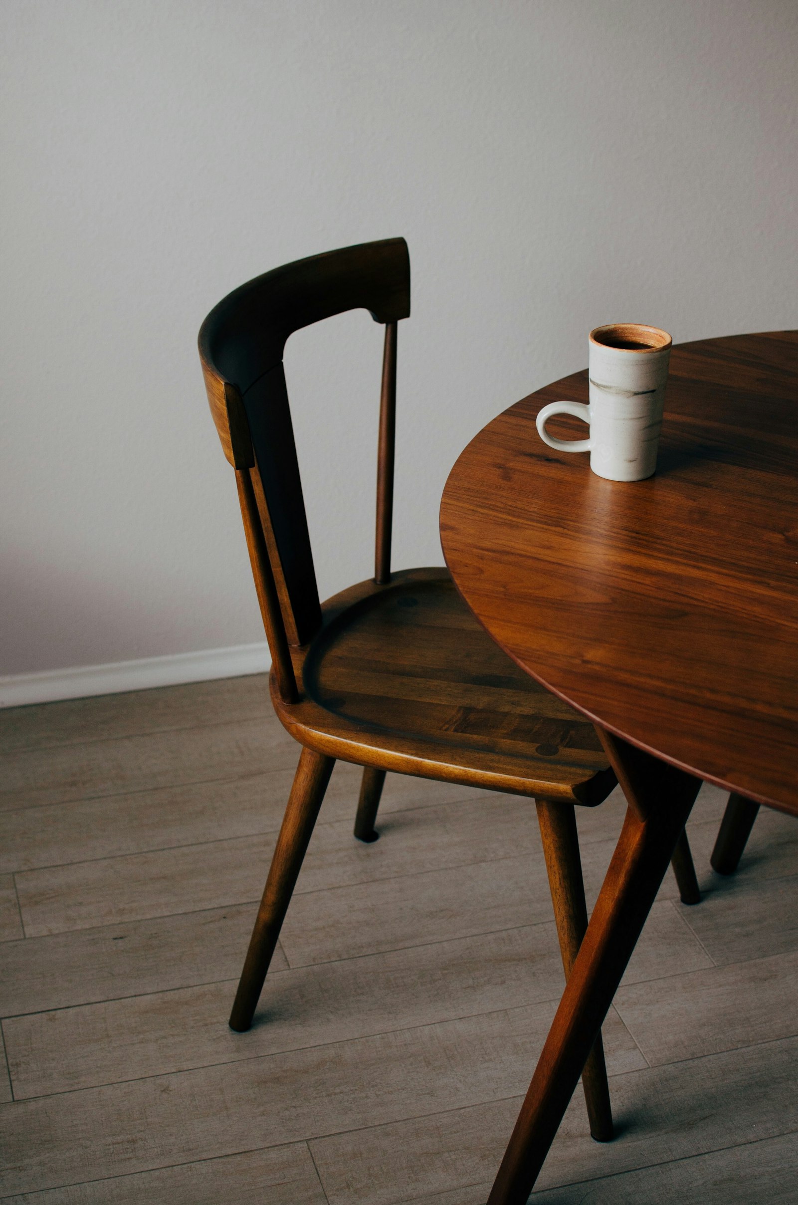 Kaffeebecher auf einem runden Holztisch.