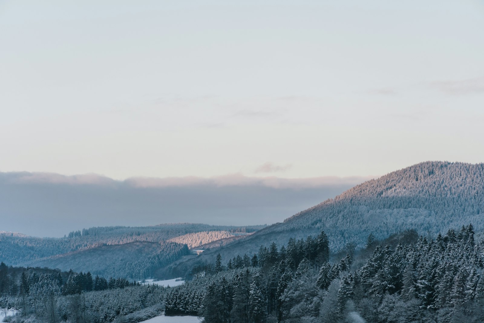 Verschneite Hügel und Wälder im Winter.